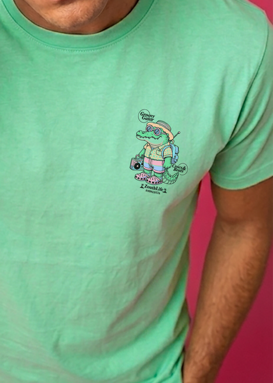 camiseta color verde menta de zouth life con diseño estampado en pecho pequeño de un cocodrilo playero con sandalias crocs y radio. fotografia de estudio.vista frontal