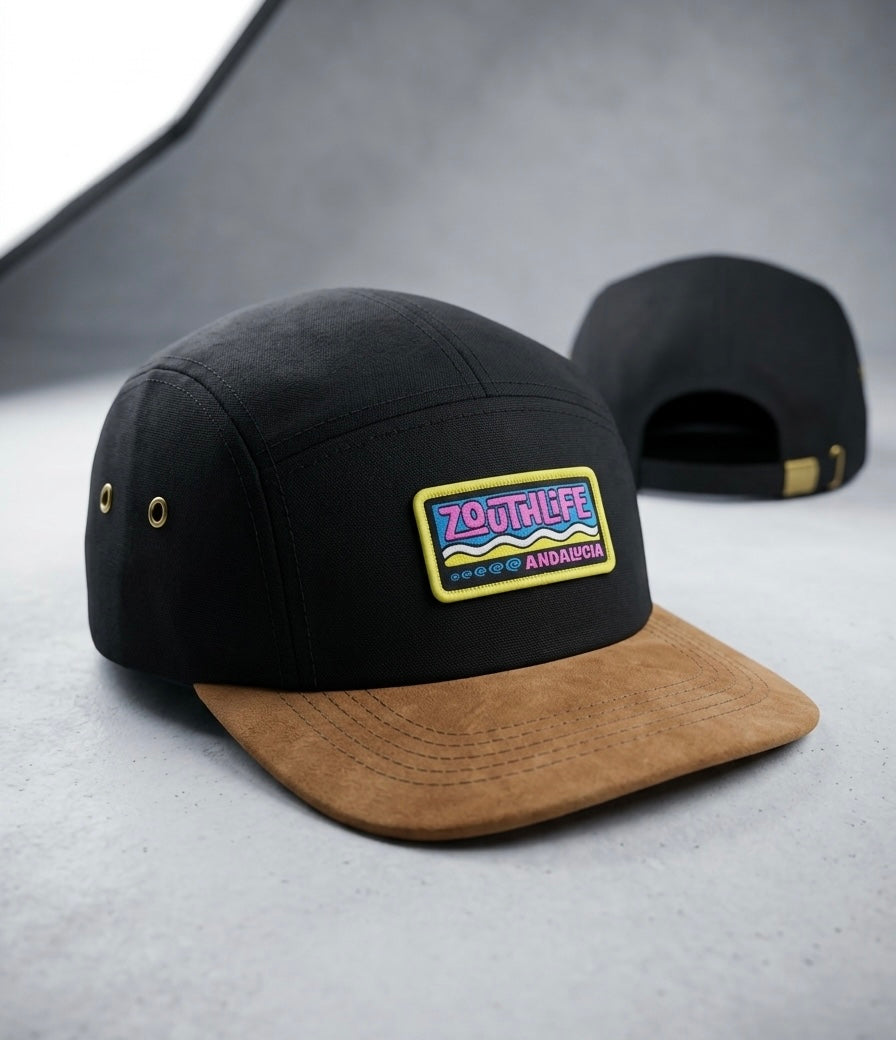 Gorra tipo "5-panel" de color negro con visera de gamuza marrón, con parche bordado frontal "ZOUTH LIFE ANDALUCIA" en colores rosa, azul y amarillo,