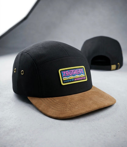 Gorra tipo "5-panel" de color negro con visera de gamuza marrón, con parche bordado frontal "ZOUTH LIFE ANDALUCIA" en colores rosa, azul y amarillo,
