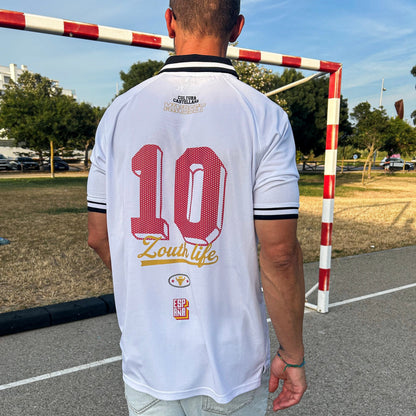 Vista trasera del polo retro de España de Zouthlife con el dorsal 10 en color rojo, tipografía de estilo noventero y logotipo dorado Cultura Castellana en una pista exterior.
