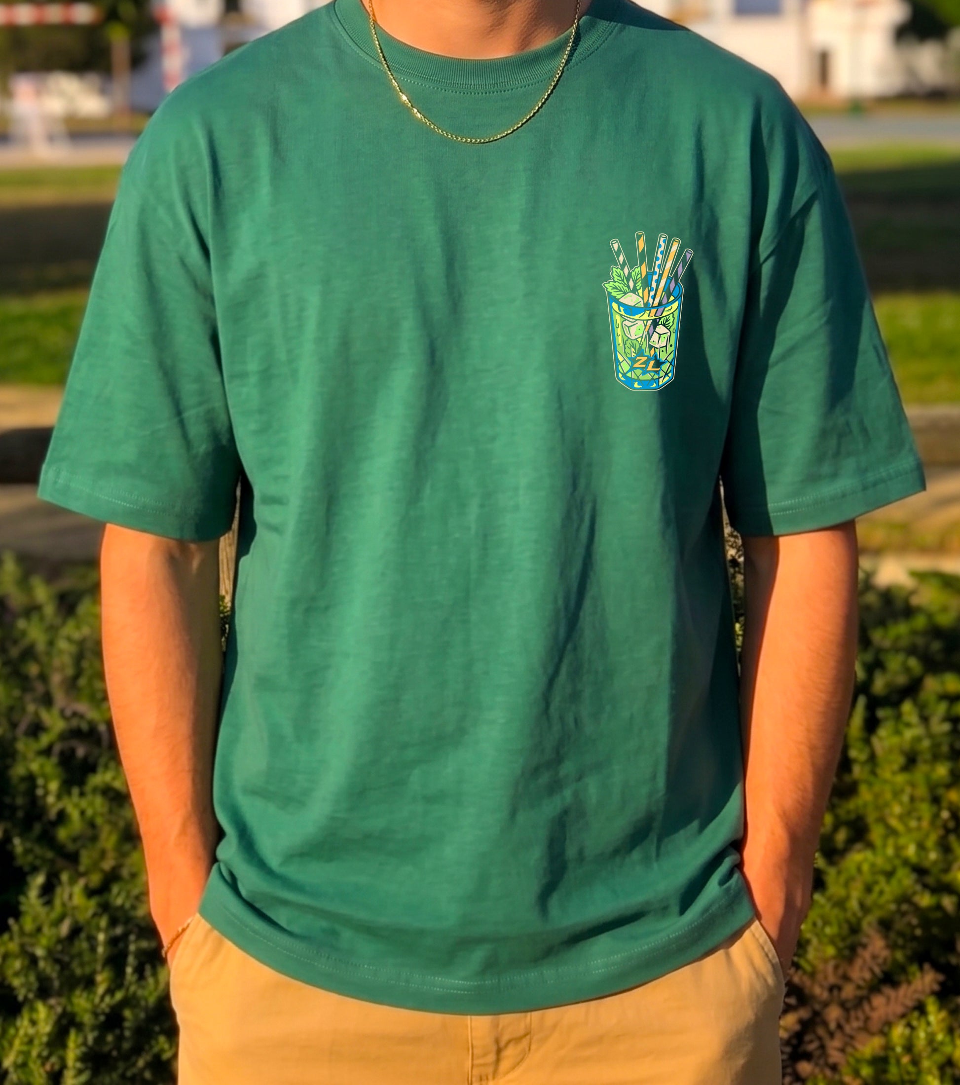 camiseta oversize verde zouthlife con diseño de un vaso de rebujito andaluz en pecho. vista frontal