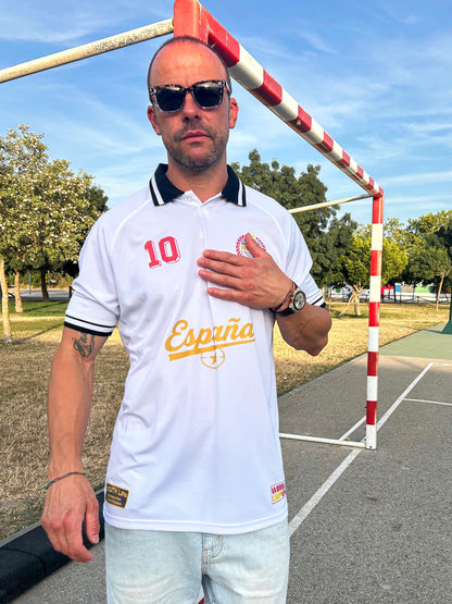 Modelo  con el Polo Retro España Mundial 2026 color blanco vista frontal combinado con bermudas vaqueras claras y zapatillas de estilo urbano blockecore.